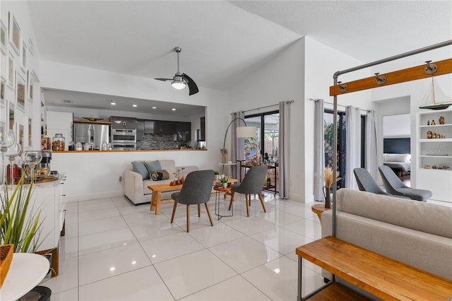 living area with vaulted ceiling, ceiling fan, tile patterned flooring, and baseboards