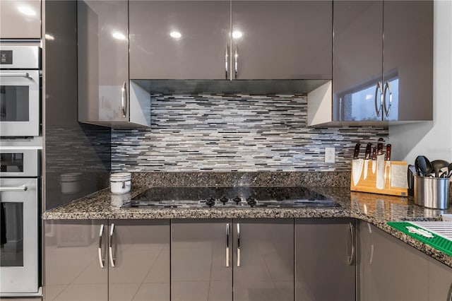 kitchen featuring black electric stovetop, modern cabinets, oven, and decorative backsplash