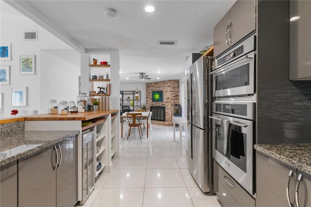 kitchen featuring light tile patterned floors, appliances with stainless steel finishes, visible vents, and a ceiling fan