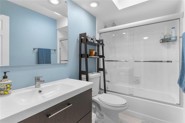 bathroom featuring toilet, shower / bath combination with glass door, and vanity