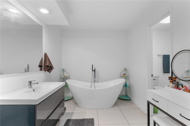 bathroom featuring recessed lighting, a freestanding bath, vanity, tile patterned flooring, and baseboards