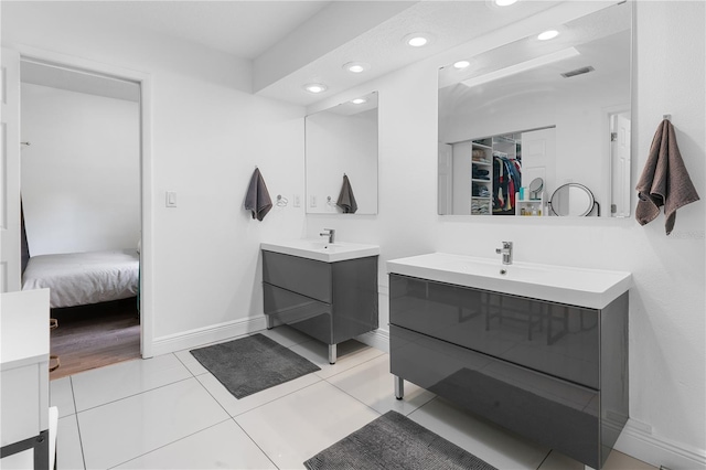 full bathroom with a sink, two vanities, visible vents, and tile patterned floors