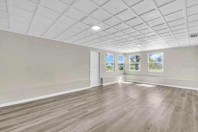 empty room with visible vents, baseboards, and wood finished floors