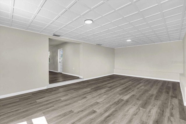 empty room featuring visible vents, baseboards, and wood finished floors