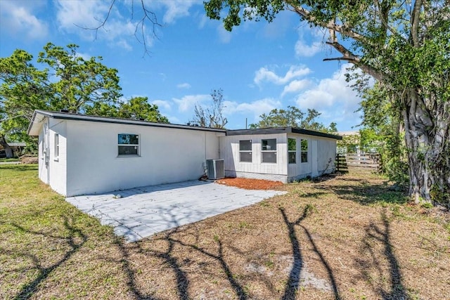 rear view of property featuring central AC, a yard, and a patio area