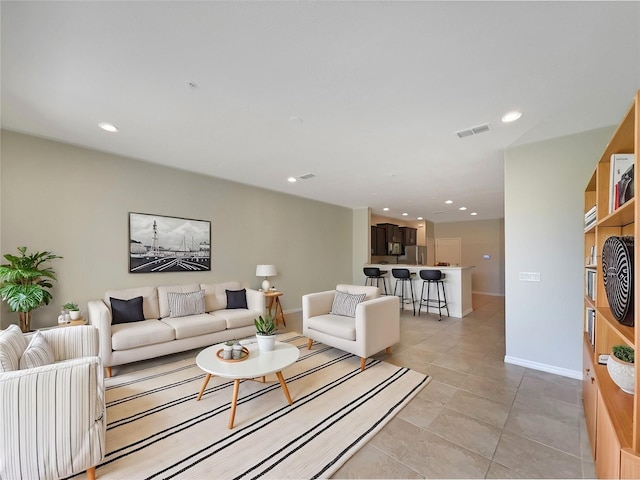 living room featuring light tile patterned floors, recessed lighting, visible vents, and baseboards