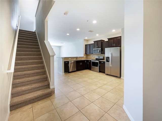 kitchen featuring light tile patterned floors, recessed lighting, a sink, appliances with stainless steel finishes, and tasteful backsplash