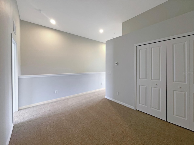 unfurnished bedroom featuring a closet, carpet flooring, recessed lighting, and baseboards