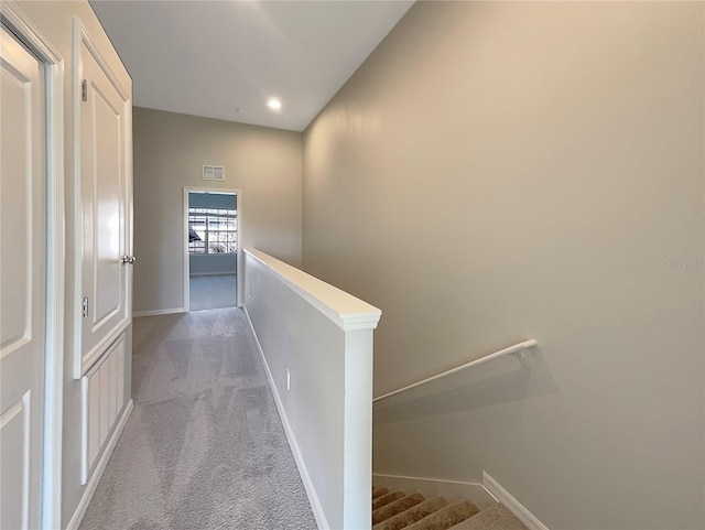 hall with visible vents, baseboards, recessed lighting, carpet flooring, and an upstairs landing