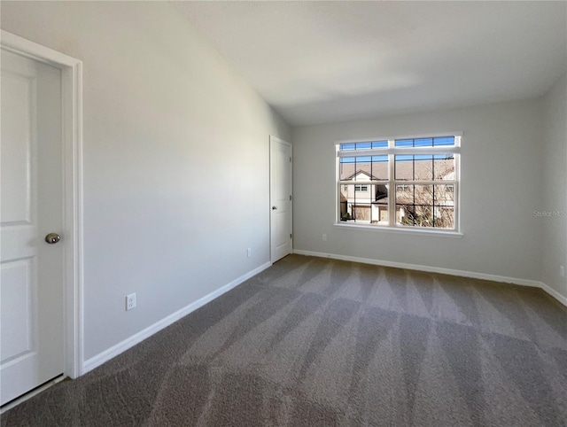 unfurnished room with carpet, baseboards, and vaulted ceiling