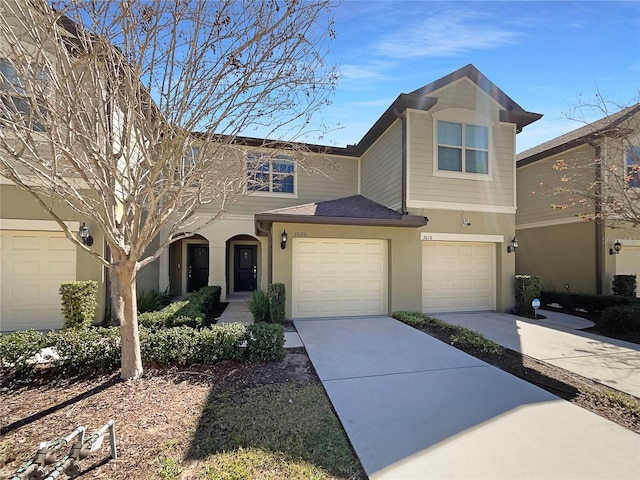 view of front facade featuring stucco siding, a garage, and driveway