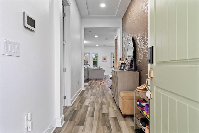 hallway with baseboards, wood finished floors, and recessed lighting