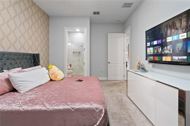 bedroom with light carpet, ensuite bath, visible vents, and baseboards