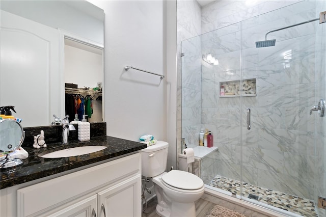 full bathroom with a stall shower, vanity, and toilet