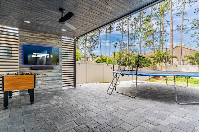 view of patio / terrace featuring a trampoline, ceiling fan, and fence