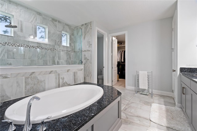 full bathroom featuring a garden tub, vanity, marble finish floor, a spacious closet, and walk in shower