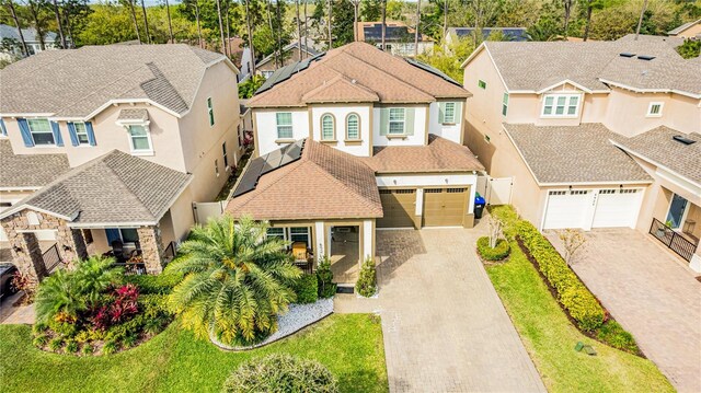 view of front facade featuring roof with shingles, a residential view, decorative driveway, and stucco siding