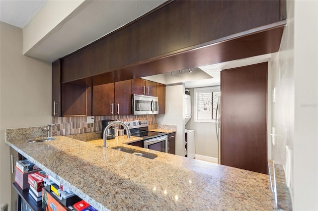 kitchen with light stone counters, a sink, appliances with stainless steel finishes, decorative backsplash, and open shelves