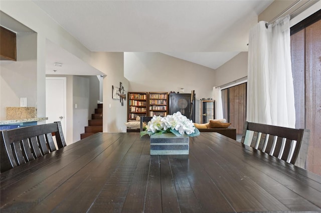 dining area with stairs, lofted ceiling, and hardwood / wood-style flooring