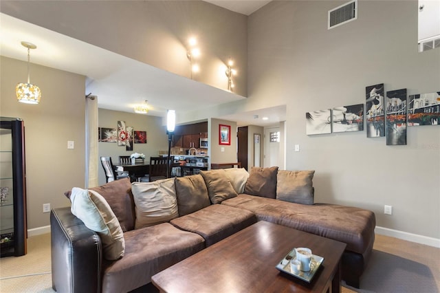 living room with light colored carpet, visible vents, and baseboards