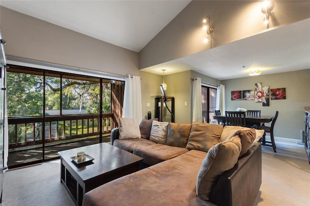 living area with light carpet, high vaulted ceiling, and baseboards