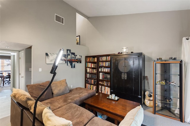 living room featuring high vaulted ceiling and visible vents