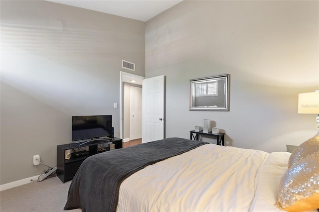 bedroom with a high ceiling, carpet, visible vents, and baseboards