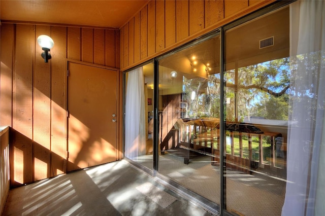 exterior space featuring board and batten siding, a balcony, and visible vents