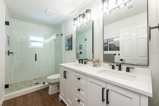 full bath featuring a sink, visible vents, a stall shower, and wood finished floors