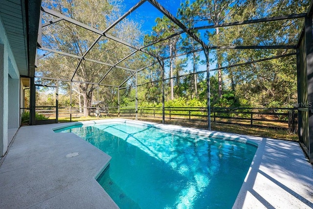 view of pool with a patio area, glass enclosure, and a fenced in pool