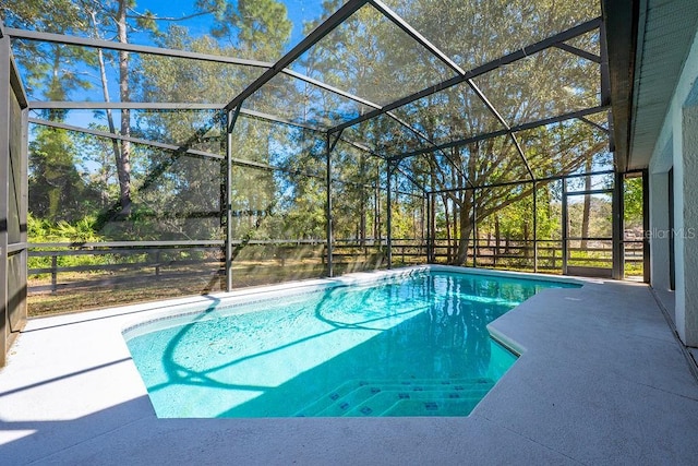 outdoor pool with a lanai and a patio area