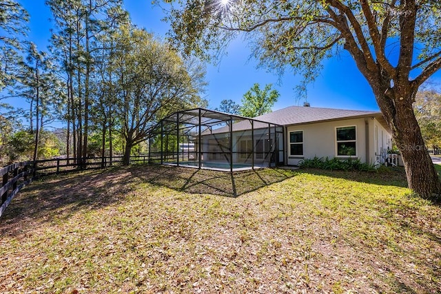 view of yard featuring glass enclosure, a fenced in pool, and fence