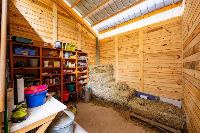 office space with vaulted ceiling with skylight and wooden walls