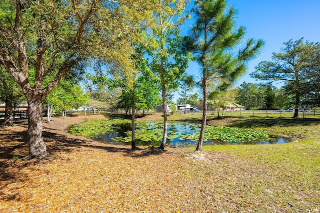 view of yard featuring a water view and fence