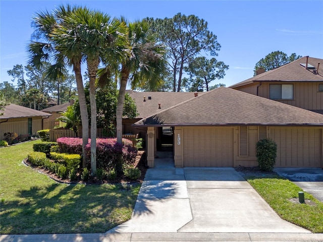 view of front of property with driveway, a shingled roof, and a front lawn