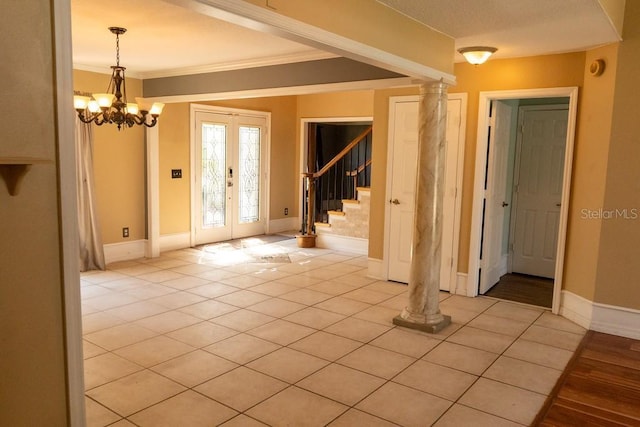 entrance foyer with stairs, crown molding, light tile patterned flooring, and french doors