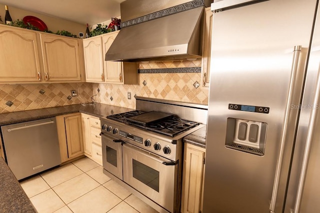 kitchen featuring dark countertops, light tile patterned floors, range hood, and appliances with stainless steel finishes