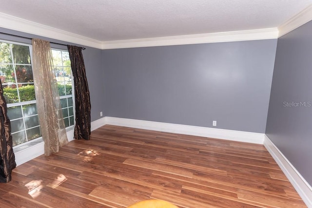 unfurnished room featuring baseboards, a textured ceiling, wood finished floors, and crown molding