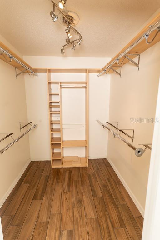 walk in closet with wood finished floors