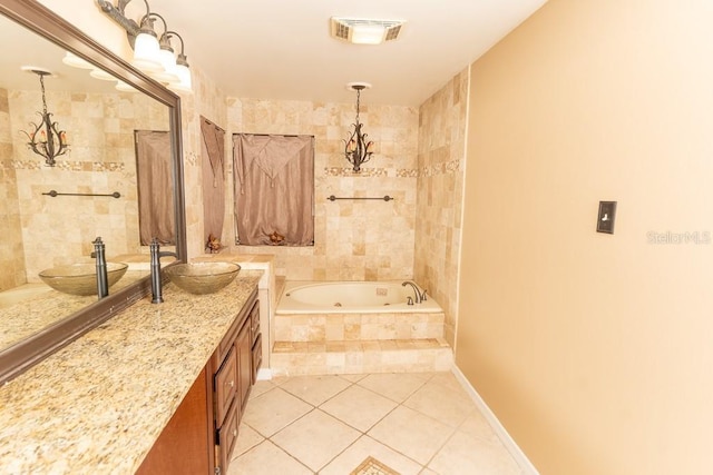 full bath featuring visible vents, a garden tub, tile patterned flooring, baseboards, and vanity