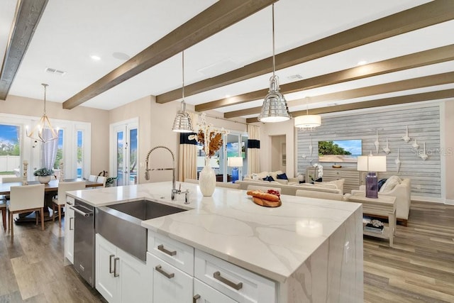 kitchen featuring plenty of natural light, a sink, visible vents, and light wood-style floors