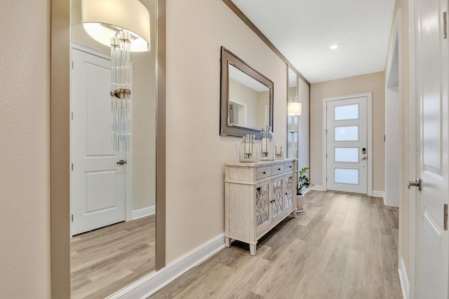 doorway with light wood-style flooring and baseboards