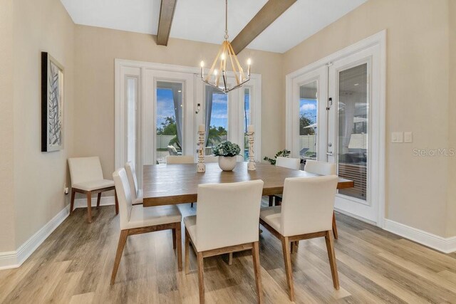 dining area featuring a notable chandelier, light wood-style floors, baseboards, french doors, and beam ceiling