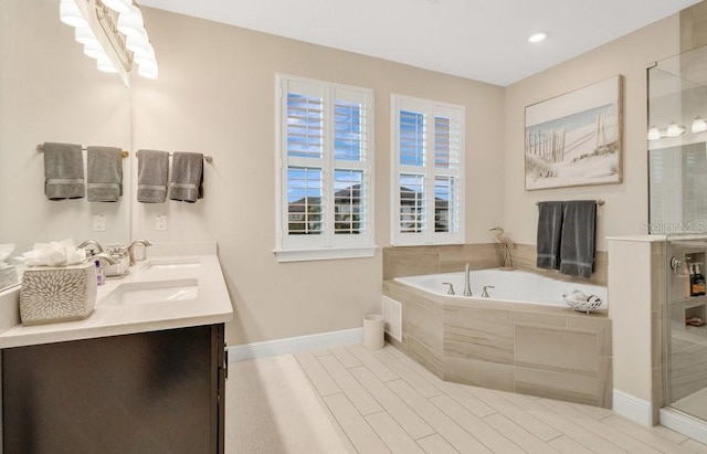 bathroom featuring double vanity, a stall shower, a sink, baseboards, and a bath