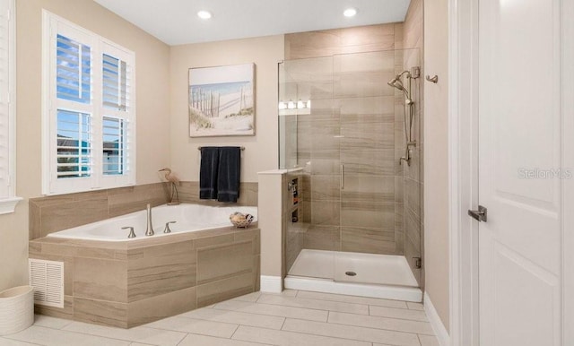 bathroom featuring visible vents, a garden tub, and a shower stall