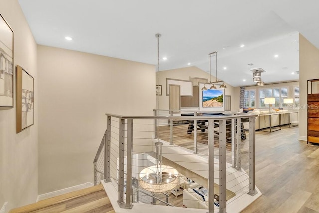 interior space with lofted ceiling, baseboards, wood finished floors, and recessed lighting