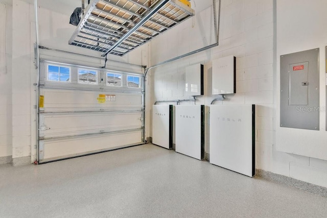 garage featuring concrete block wall and electric panel