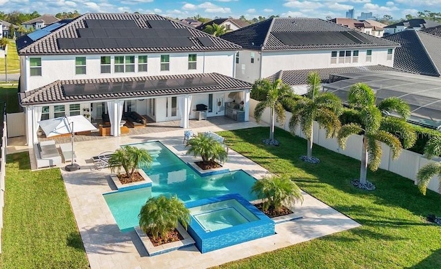 back of property with a tile roof, a patio, a lawn, and a fenced backyard