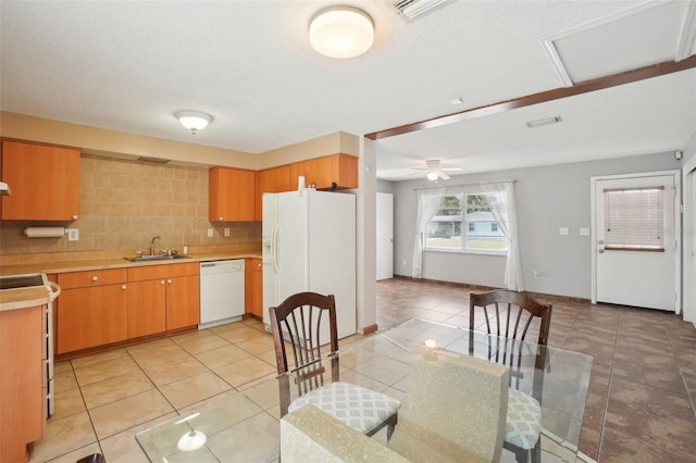 kitchen with light tile patterned flooring, white appliances, a sink, light countertops, and backsplash