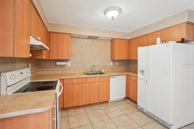 kitchen featuring light tile patterned floors, tasteful backsplash, a sink, white appliances, and under cabinet range hood